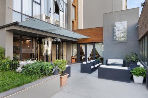 a lobby of a building with couches and plants at Iveria Inn Hotel in Tbilisi City