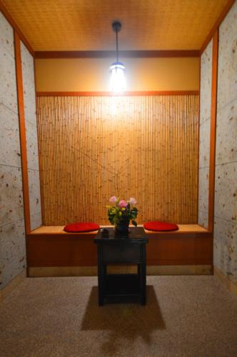 a room with a table with a vase of flowers on it at Futari Shizuka in Komagane