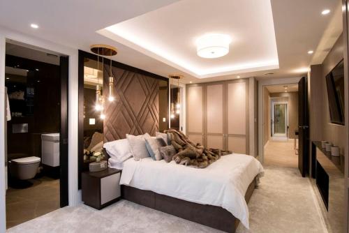 a bedroom with a large bed and a bathroom at New, luxury 3 bed duplex in Covent Garden in London