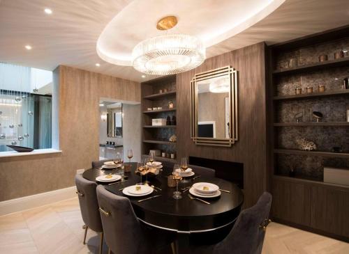 a dining room with a black table and chairs at New, luxury 3 bed duplex in Covent Garden in London
