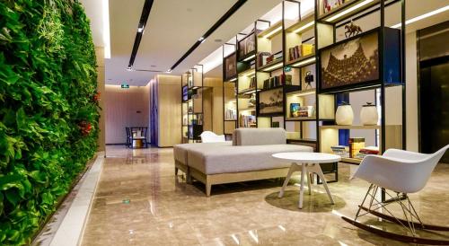 Habitación con cama y pared verde en Atour Hotel Tianjin Binhai Second Avenue Branch en Binhai