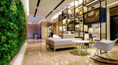 a room with a bed and a green wall at Atour Hotel Tianjin Binhai Second Avenue Branch in Binhai
