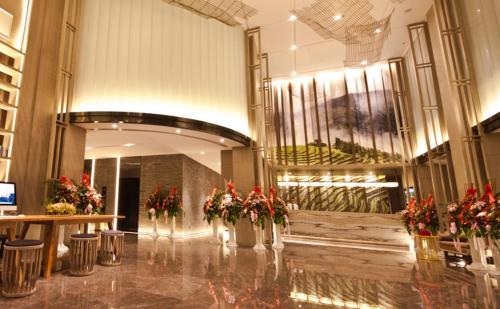 a lobby with flowers in vases in a building at Atour Hotel Hailian Fuzhou in Fuzhou