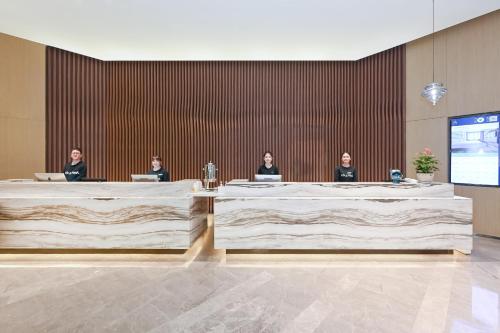 a group of people sitting at tables in a room at Atour Hotel Railway Station Dalian in Dalian