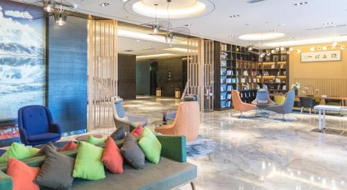 a lobby with a couch with colorful pillows at Atour Hotel (Turpan Wenhua West Road) in Turfan