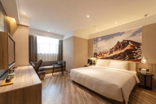 Pokój hotelowy z łóżkiem i biurkiem w obiekcie Atour Hotel (Urumqi Renmin Cinema) w mieście Urumczi
