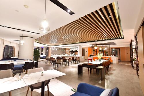 銀川市にあるAtour Hotel Yinchuan Gulou Pedestrian Streetのテーブルと椅子のあるレストラン、ダイニングルーム