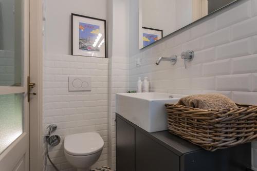 Baño blanco con lavabo y aseo en Casa Paradiso by Wonderful Italy, en Turín