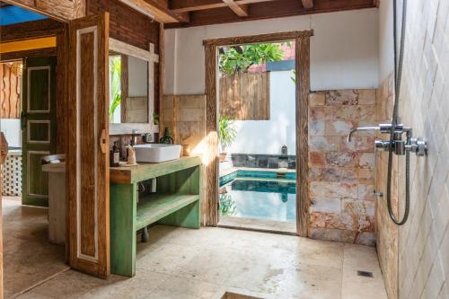 a bathroom with a sink and a swimming pool at Jawa House Private Villas in Gili Trawangan