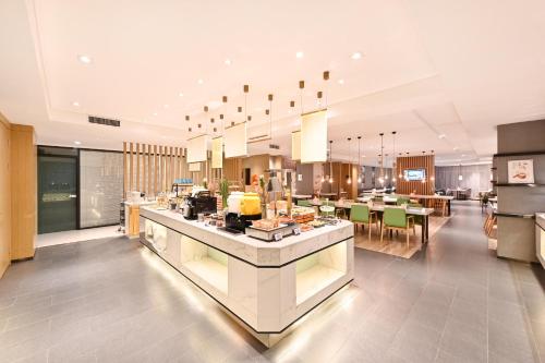 a large kitchen and dining room with tables and chairs at Atour Hotel Railway Station Dalian in Dalian