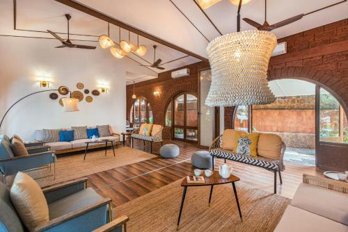 an open living room with a large chandelier at SaffronStays Athaang, Dapoli in Ānjarle