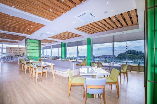 un ristorante con tavoli, sedie e finestre di Atour Hotel Xiamen Huandao South Road a Xiamen
