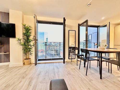 a living room with a table and chairs and a large window at City centre, Top floor apartment, Two balconies in Manchester