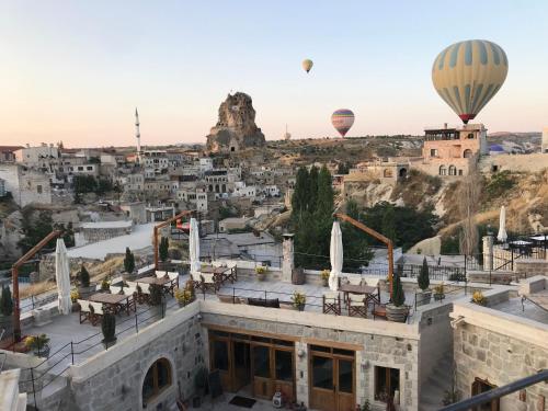 zwei Heißluftballons fliegen über die Stadt in der Unterkunft Doda Artisanal Cave Hotel - Adults Only - in Nevşehir