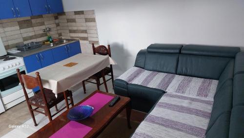 a kitchen and a living room with a table and a couch at Apartman M in Trebinje