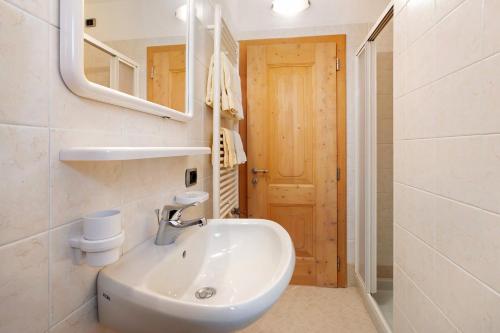 W łazience znajduje się umywalka i lustro. w obiekcie Al Bait da Marangona w Livigno