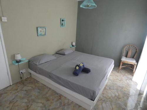 ein Schlafzimmer mit einem Bett mit einem ausgestopften Tier darauf in der Unterkunft Sea and sand in Pointe d'Esny
