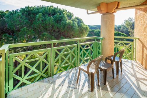 two chairs on a balcony with a green railing at Garrigae Domaine de l'Esterel - piscine & SPA Cinq Mondes in Saint-Raphaël