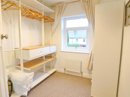 um closet com armários brancos e uma janela em Pass the Keys King Bed House Next To Heaton Park WM Discounts em Manchester