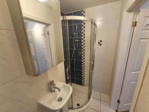 a bathroom with a sink and a shower at Large 4 bedrooms golders green in London
