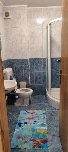 a bathroom with two toilets and a shower and a rug at Apartman Svalina in Kupres