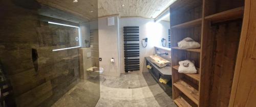a bathroom with a shower and a sink and a toilet at Hotel Garni Romantik in Fügen