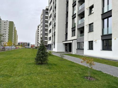 a grassy yard next to a large building at Coresi Mall Area Studios & Apartments by GLAM in Braşov