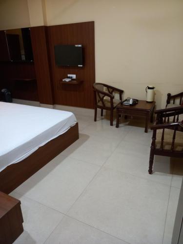 a bedroom with a bed and a table and a tv at ROYAL RESIDENCY in Gangānagar
