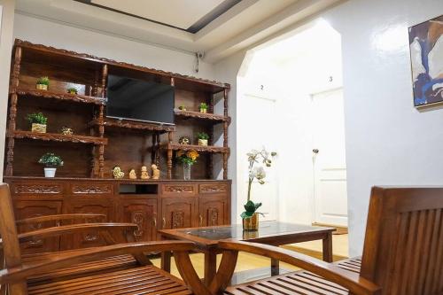 a dining room with a table and a entertainment center at Casa D' Hiyas Whole House Homestay in Panglao in Panglao