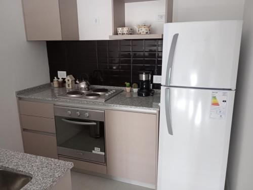 a kitchen with a white refrigerator and a stove at Monoambiente nuevo , Zona Guemes in Mar del Plata