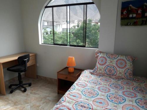 1 dormitorio con cama, escritorio y ventana en Terraza más habitaciones en La Molina en Lima