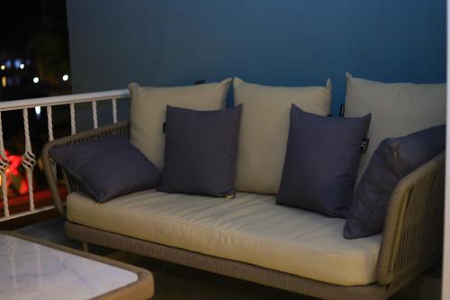 a couch with blue pillows sitting on a balcony at New Marina Hurghada Suite in Hurghada