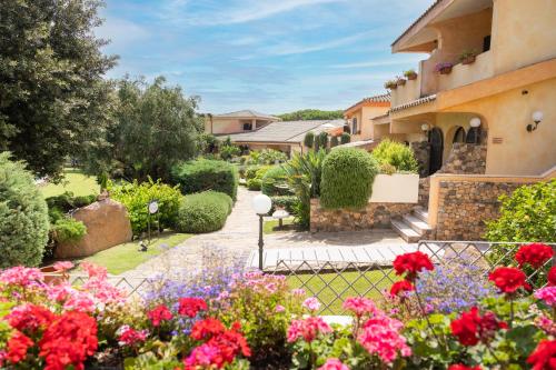 a garden of flowers in front of a building at Hotel Baia Di Nora in Pula