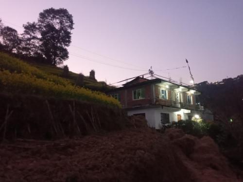 a house on the side of a hill at night at Unique point home stay in Nagarkot