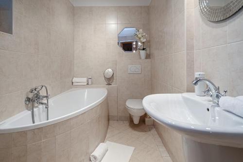 een badkamer met een bad, een toilet en een wastafel bij Apartament Karpielówka View Od-nowa in Kościelisko