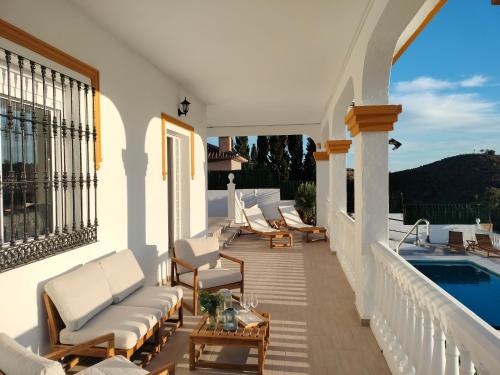 a balcony with lounge chairs and a swimming pool at Chalet Antonio in Benalmádena