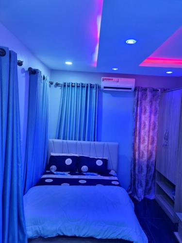 Habitación con cama con luces azules. en Hencap apartment services, en Lagos