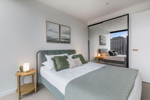 sypialnia z dużym łóżkiem z zielonymi poduszkami w obiekcie Posh Perch on Collins - A Cosy Couple's Haven w Melbourne
