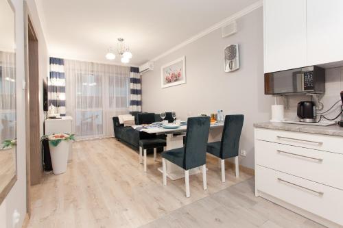 a kitchen and dining room with a table and chairs at Apartament Kasprowicza 20 A z garażen in Kołobrzeg