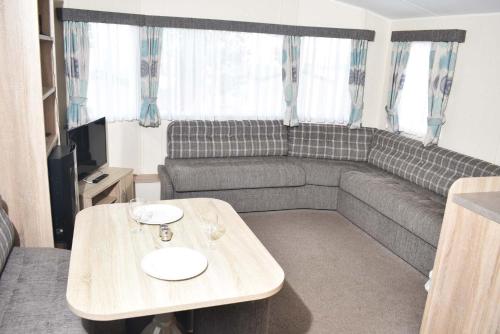 a living room with a couch and a table at Rio Gold LC21 in Minehead