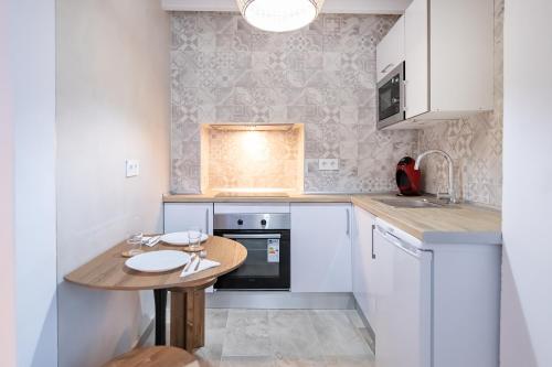 a small kitchen with a wooden table in it at BHost - Silos in Tarifa