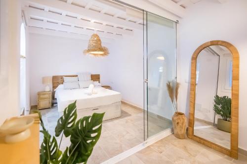 a bedroom with a bed and a glass shower at BHost - Silos in Tarifa