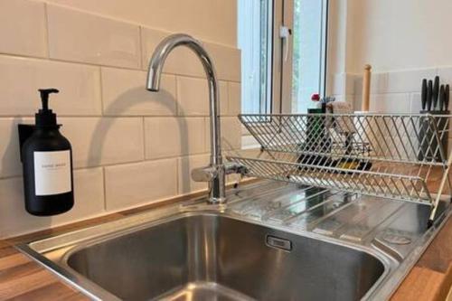 a sink in a kitchen with a bottle of wine at Cosy One Bedroom Apartment in Exeter