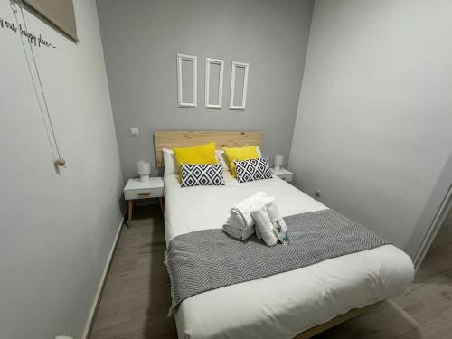 Un dormitorio con una cama grande con almohadas amarillas y blancas en Market Martinez De La Riva I, en Madrid