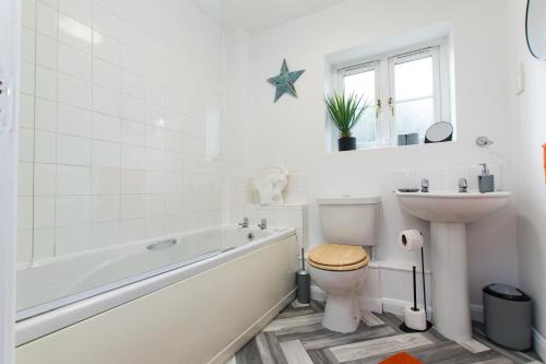 a bathroom with a tub and a toilet and a sink at Newly Renovated Modern House with FREE Parking in Nottingham
