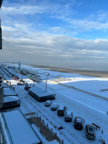 a parking lot covered in snow next to a beach at studionusi in Blankenberge