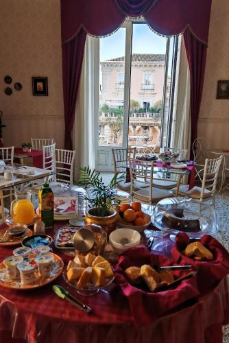 een tafel met eten in een kamer met een raam bij Bellini Inn Deluxe in Catania