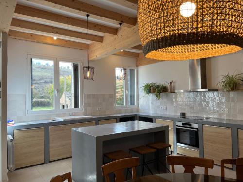 a kitchen with a table and a large chandelier at El Pecu Casa Rural in Bustillo del Páramo