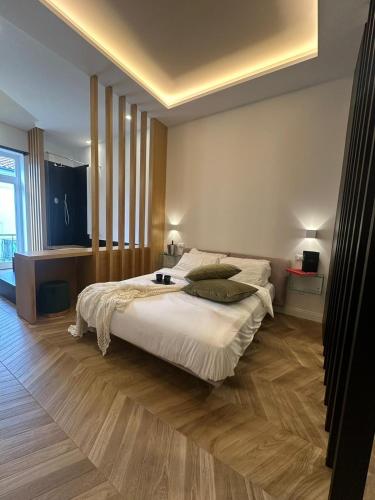 a bedroom with a large bed with white sheets at Belladonna Luxury Apartment in Cava deʼ Tirreni