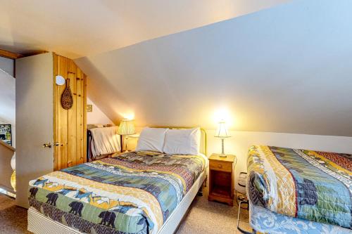 a small bedroom with two beds and two lamps at Poplar Stream Chalet in Carrabassett